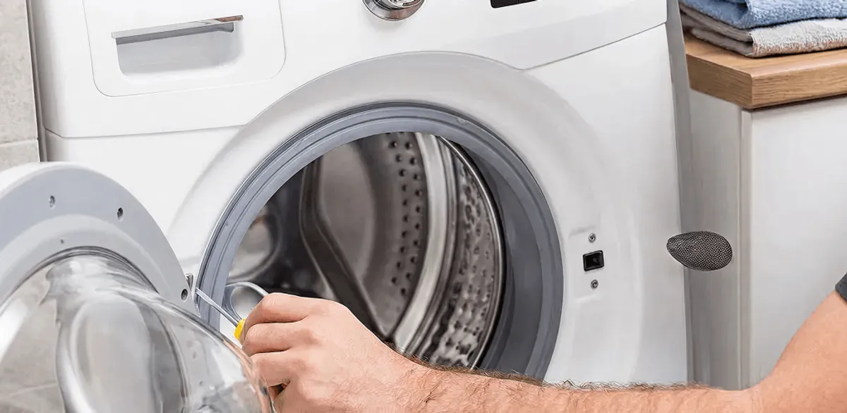 Handyman repairing a front-load washing machine and inspecting the drum in Henderson, NV