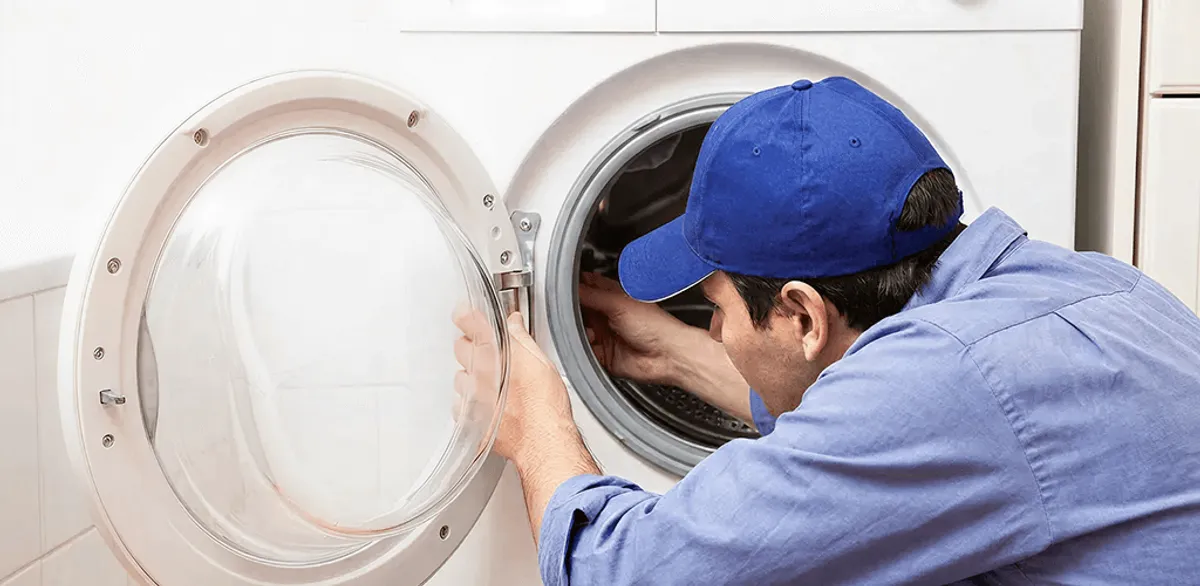 Washing machine repair handyman inspecting a front-load washer drum in Henderson, NV