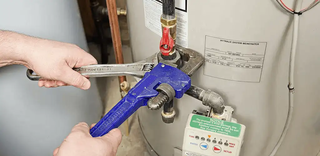 Water heater repair technician tightening the shutoff valve and supply line in Henderson, NV